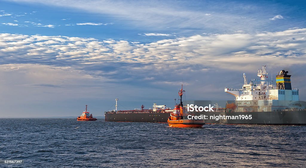 Ship with tugs Tanker ship with escorting tugs leaving port. 2015 Stock Photo