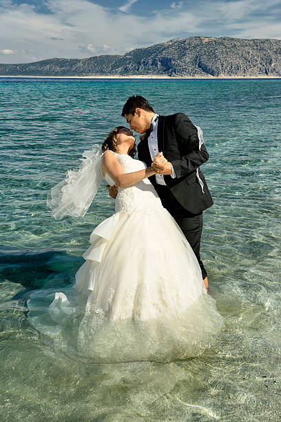istock Bride and groom walking on the beach 531570163