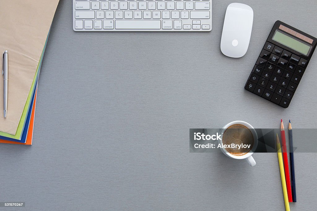 Office workplace at morning Well organised workspace on the grey wooden table with keyboard, pens, coffee mug and other business supplies Desk Stock Photo