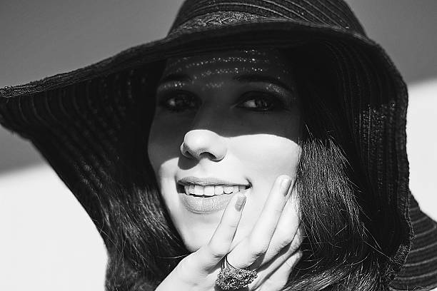 istock Smiling woman in black raffia hat. Gold openwork jewelry. 531571539