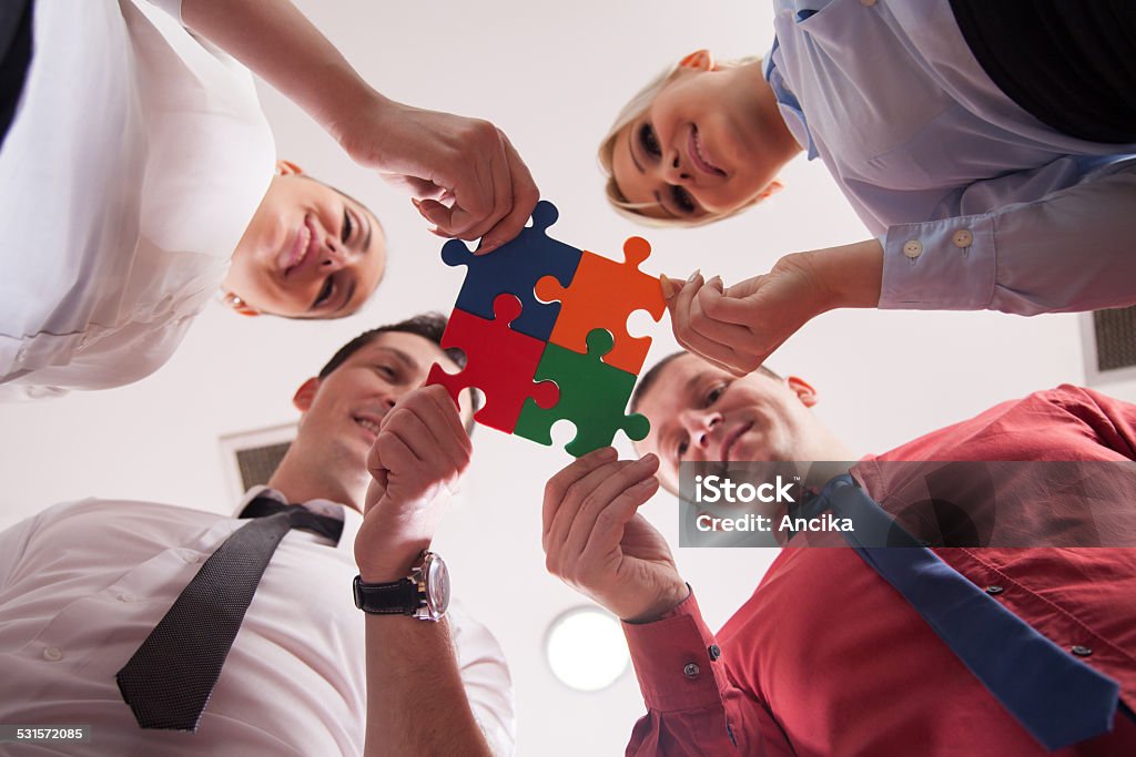 business puzzle Group of business people assembling jigsaw puzzle and represent team support and help concept in office 2015 Stock Photo