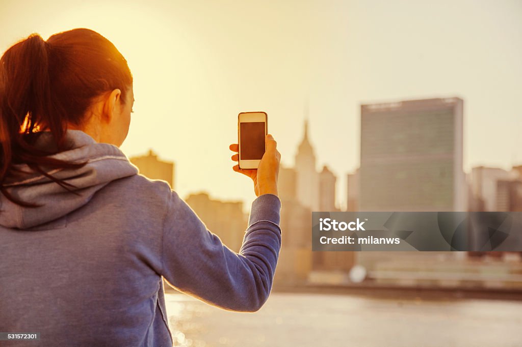 woman making photos with smartphone Young woman making photos with smartphone 2015 Stock Photo