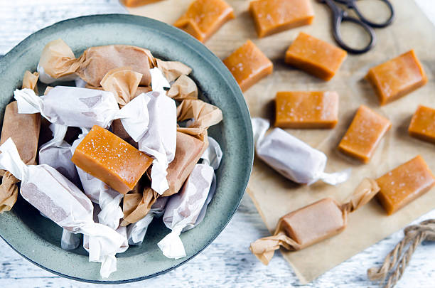 Sweet caramel toffee  caramels Sweet caramel toffee  caramels on wooden table chewy photos stock pictures, royalty-free photos & images