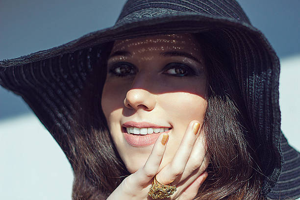 istock Smiling woman in black raffia hat. Gold openwork jewelry. 531573261