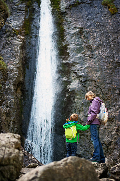istock Mother and son trekking by the waterfall 531579945