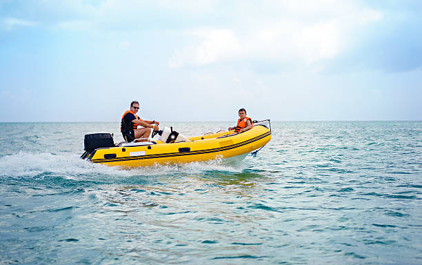 Rigid inflatable boat father and son driving a Rigid inflatable speed boat in the caribbean family motorboat stock pictures, royalty-free photos & images