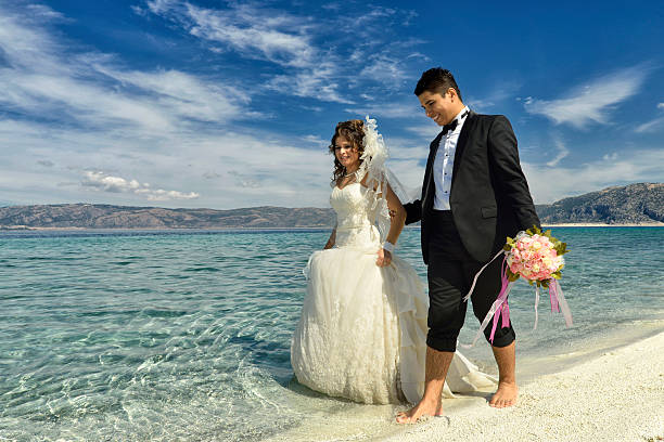 istock Bride and groom walking on the beach 531598239
