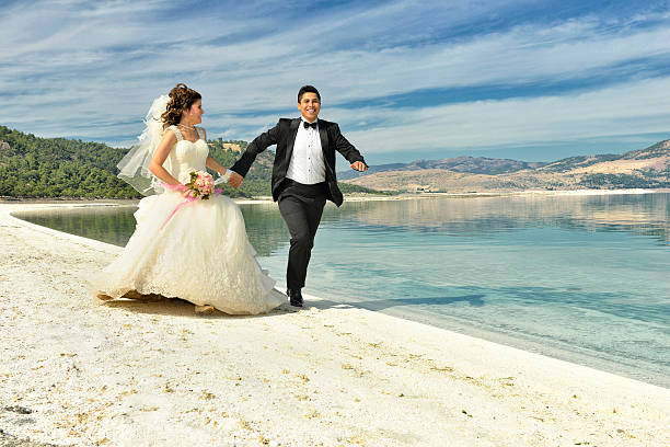 istock Bride and groom running on the beach 531598617