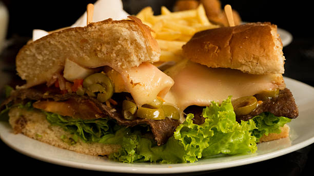 Uruguayan Chivito OLYMPUS DIGITAL CAMERAChivato is an uruguayan beef sandwich, that includes lettuce, tomato, bacon, ham, red pepper, fried eggs, mozzarella cheese, olives and depending on the restaurant more ingredients. cedar waxwing stock pictures, royalty-free photos & images
