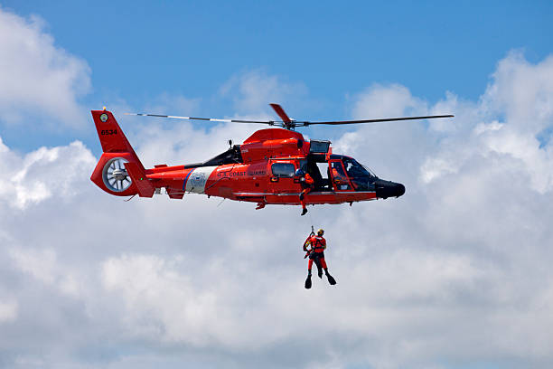 Coast Guard Rescue Helicopter Cape May, New Jersey, USA - May 7, 2016: US Coast Guard  MH-65-C Dauphin Rescue helicopter preforming  aerial rescue maneuvers in Cape May, New Jersey aerobatics photos stock pictures, royalty-free photos & images