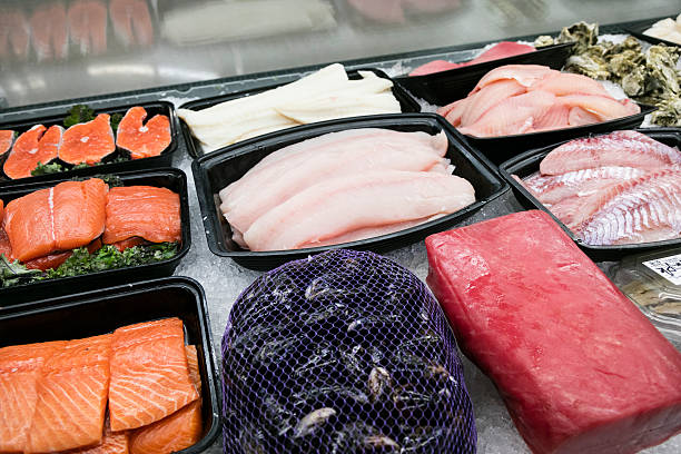 Meat Department of Grocery Store - fish Meat Department at grocery store in cooler in a row with fish collection clam stock pictures, royalty-free photos & images
