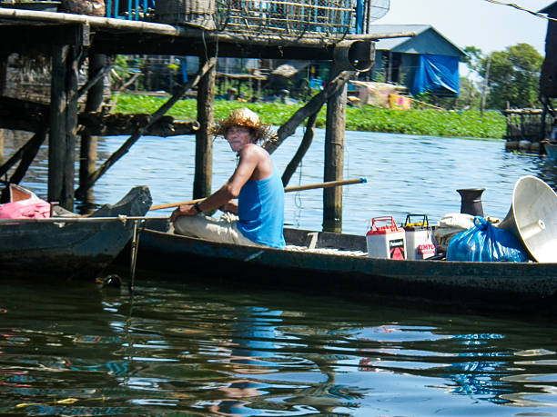 un uomo in barca sul lago tonle sap, cambogia - flood people asia cambodia foto e immagini stock