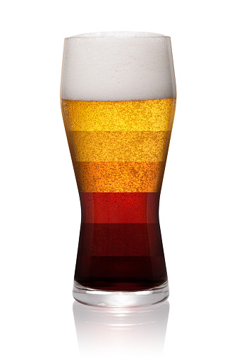 Different types of beer shown in one glass isolated on white background. With clipping path
