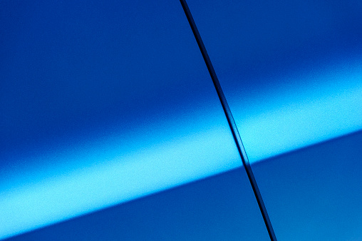 Fragment of blue steel car body. Vehicle paint coating texture. Abstract.
