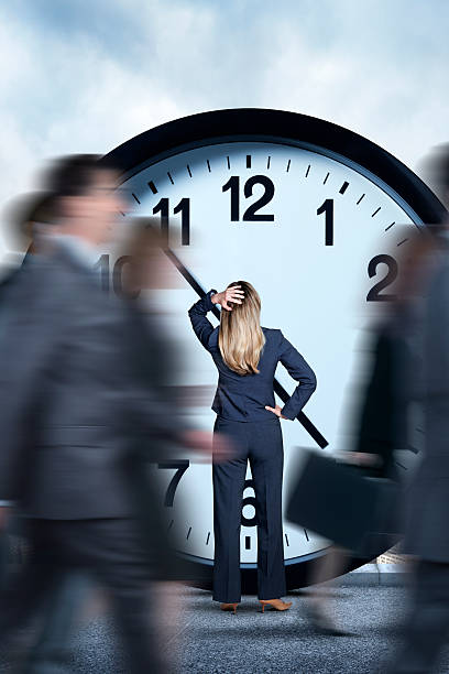 istock Businesswoman Looking At Clock As Others Pass Her By 531613166