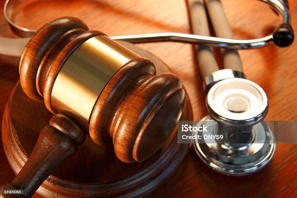 Gavel And Stethoscope A medical malpractice concept. A close up of a gavel surrounded by a stethoscope. Healthcare And Medicine Stock Photo