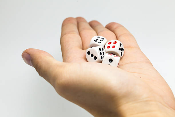 istock Human hand ready to roll the dice on white isolated 531613872