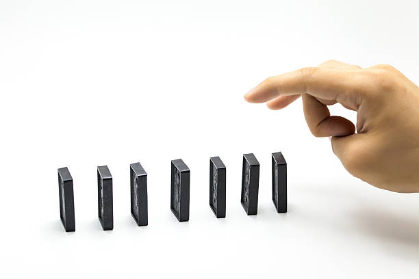 istock Hand pushing dominoes isolated on white background 531614260