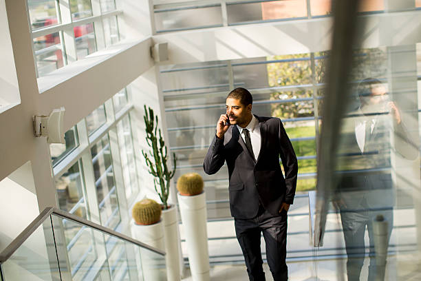 istock Handsome young black man with mobile phone in the office 531621220