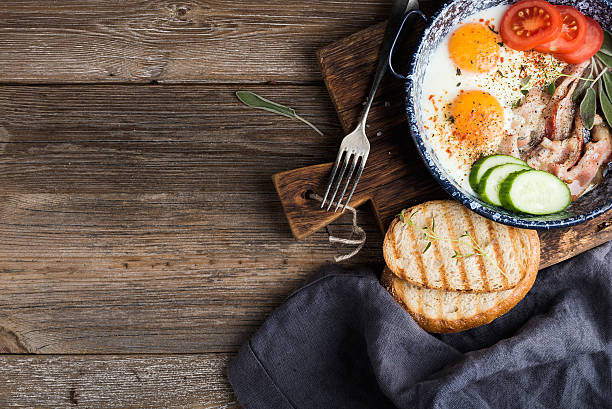 istock Breakfast set. Pan of fried eggs with bacon, fresh tomato 531621262