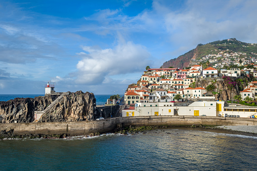 Camara de Lobos fishing village on the hills and harbor with volcanic rocks. Popular touristic resort at Madeira island, Portugal.