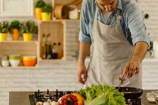 istock Chef pouring cognac on vegetables in frying pan 531621446