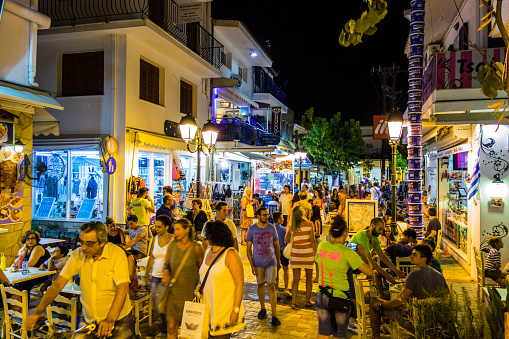 People on main street as pedestrian zone in Skiathos town on Skiathos island, Greece at night.