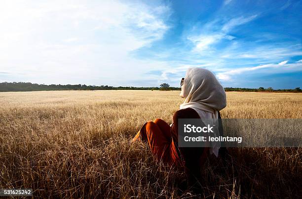 Muslim Woman Wearing Hijab Relaxing On Savanna Stock Photo - Download Image Now - Hijab, Islam, Blue