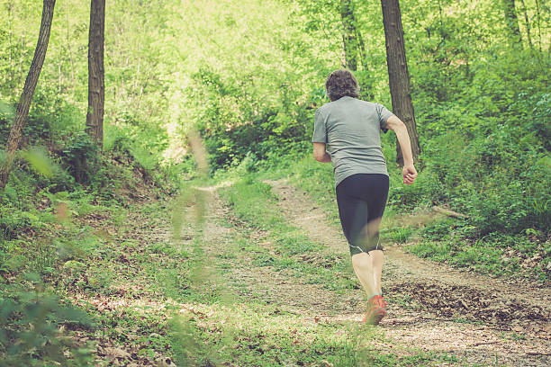 istock Caucasian elderly man running up in forest - rear view 531625714