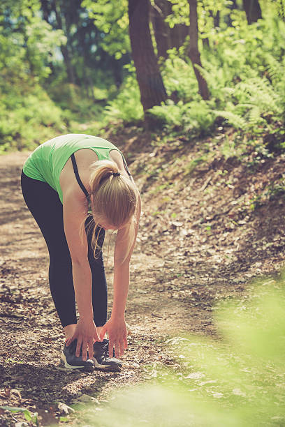 istock Young blonde woman running and stretching outdoors in nature 531626366
