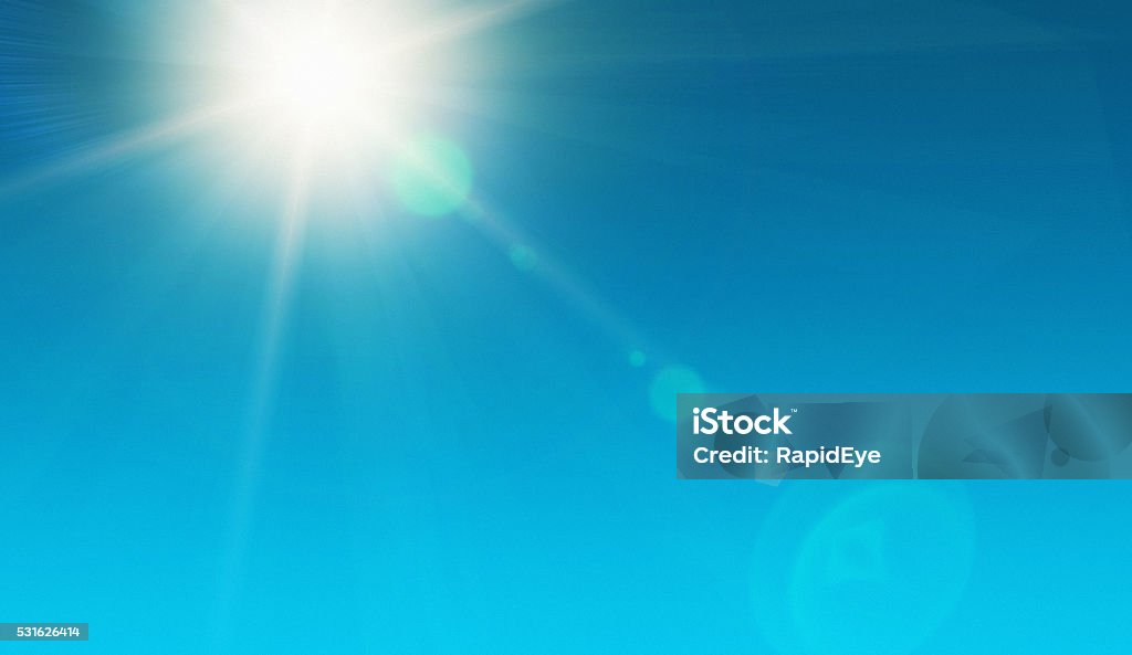 Solar energy! Blazing noonday sun in clear sky Looking up at the dazzling sun, high in the noonday sky and showing natural zoom lens flare. The source of our solar power. Ample copy space on sky. Sun Stock Photo