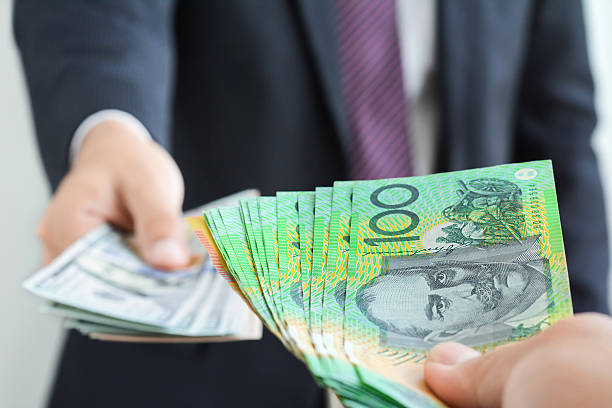 istock Hand holding Australian dollar bills exchanging with US dollar bills 531626674