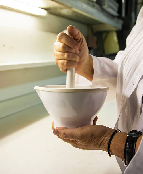 Scientist grinds up compound in porcelain mortar