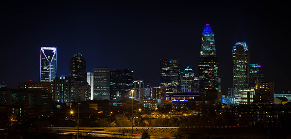 The skyline of Charlotte, North Carolina at night. The buildings lit up in blue in support of the Carolina Panthers.