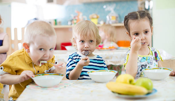 istock children eating from plates in day care centre 531630448