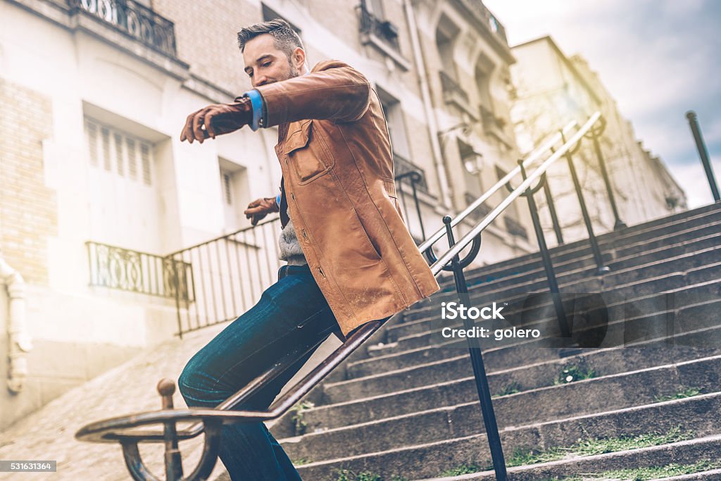 bearded man sliding down the iron balustrade of monmartre stairs bearded man sliding down the iron balustrade of monmartre stairs in Paris Men Stock Photo