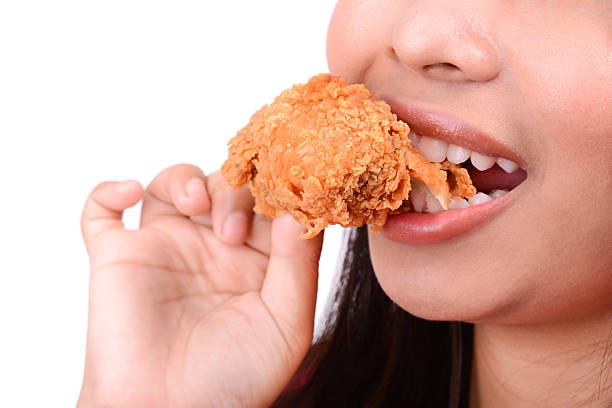 istock Woman eating fried chicken 531631568