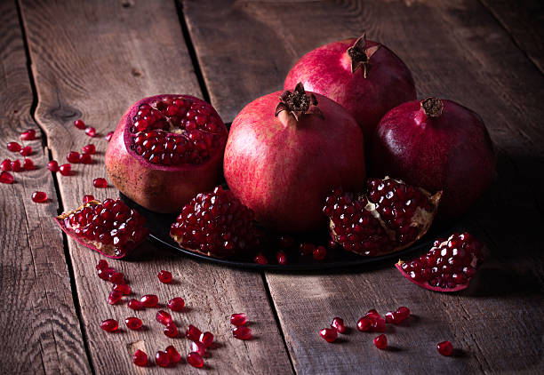 istock Some red pomegranates on old wooden table 531632013