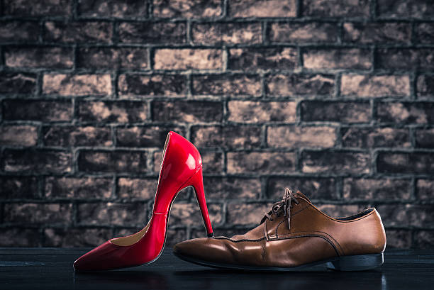 istock Red high heels is stepping on leather shoes 531632086
