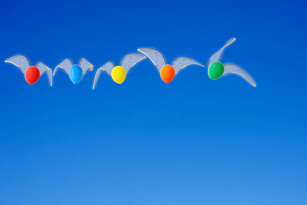 istock Multicolored balloons with wing is flying in the clear sky 531632879