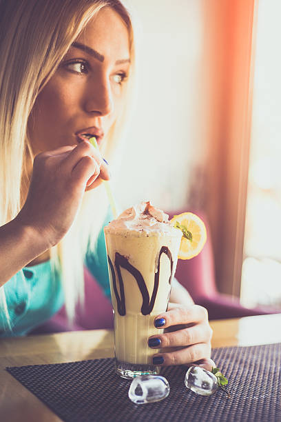 istock Happy young woman drinking lemon milk shake 531634512