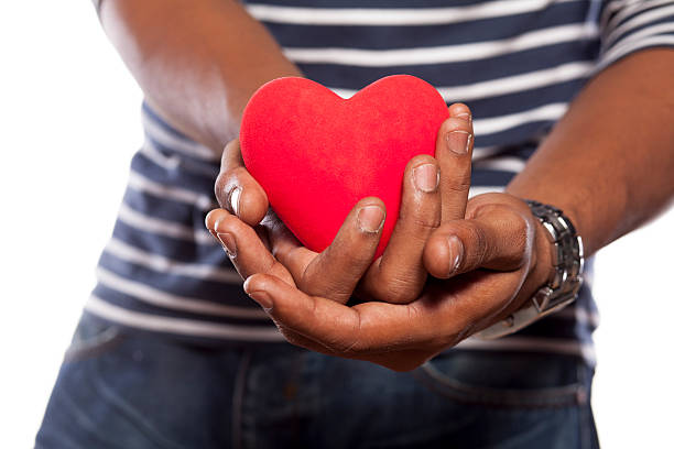 istock Dark-skinned young man holding an object in heart shape 531642799