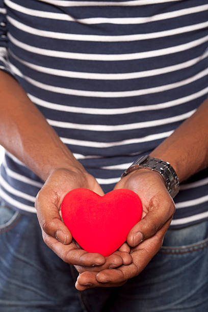 istock Dark-skinned young man holding an object in heart shape 531642837