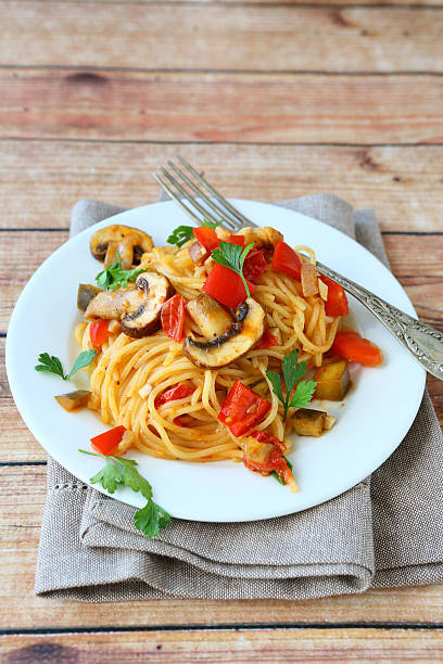 istock Pasta with mushrooms and peppers on a white plate 531643071