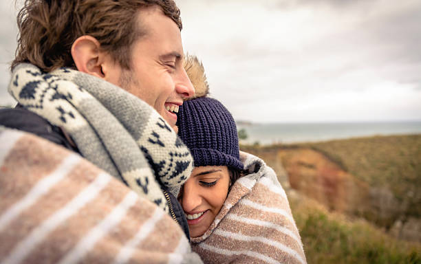 istock Young couple laughing outdoors under blanket in a cold day 531644955