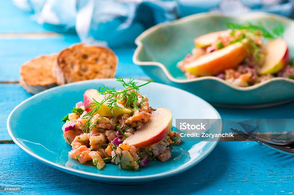 fish tartare with apple on a blue plate. 2015 Stock Photo