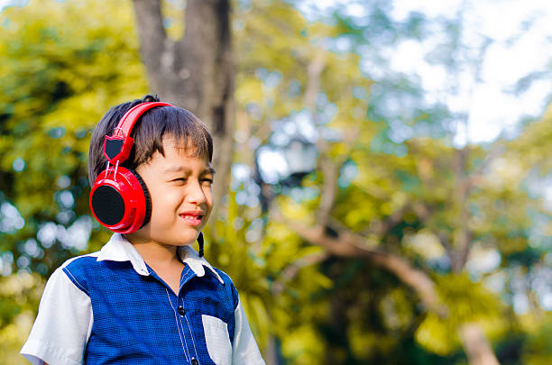 istock Little boy listening with headset in the park 531646031