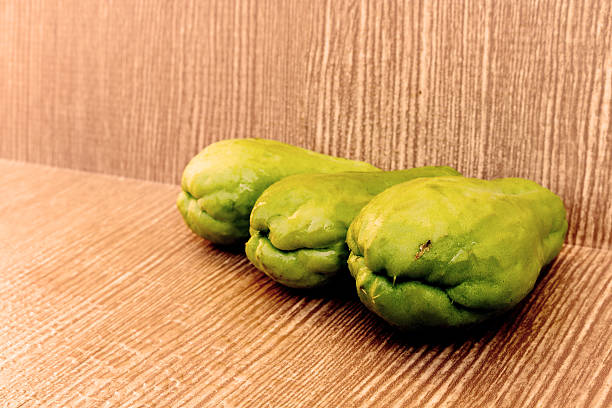 three chayote on wooden background three chayotes are on the wooden background Christophine stock pictures, royalty-free photos & images