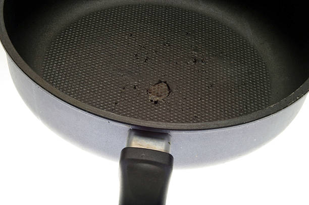 A scratched non-stick pot on a gas stovetop