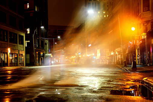 Night steam rising from manhole cover on a city street in Boston, Massachusetts